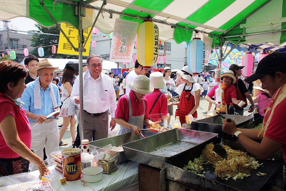 町会の焼きそばブースを激励する区長