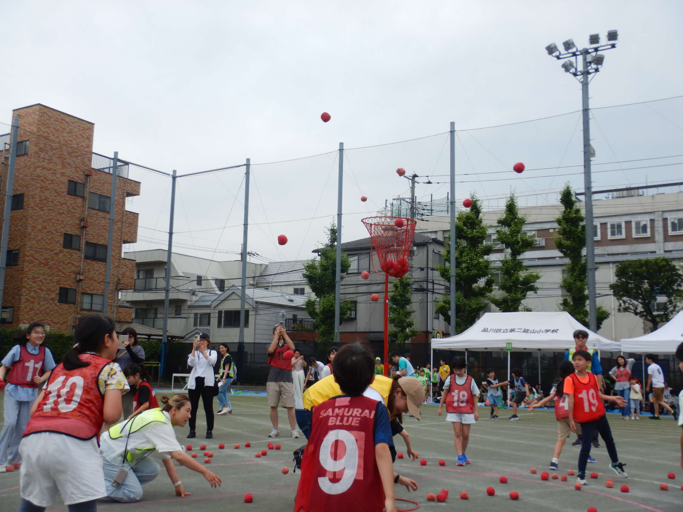 玉入れ（多くの子どもたちがカゴめがけて投入！）