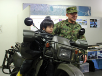 自衛隊のバイクに乗る子ども