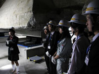 区役所庁舎地下の免震装置の説明を聞く生徒たち