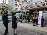 校門前で記念写真を撮る親子