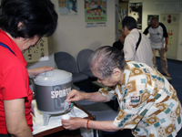 麦茶を紙コップに注ぐ利用者