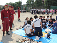 AED訓練中の大崎中生徒と区長