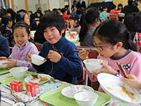 笑顔で給食を食べる子どもたち