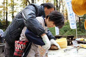 ホタテの殻むきをする親子