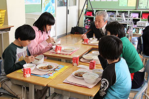 給食を食べながら体験談を話す