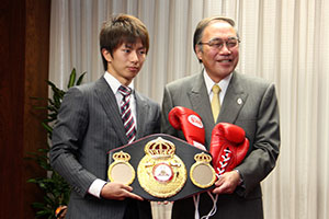 グローブを濱野区長にプレゼントする田口選手