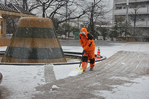 公園管理者が雪かきを行う