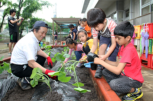 子どもたちと苗植えをする大塚さん