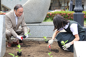 植樹する区長と生徒