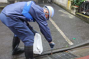 タバコの吸い殻を拾う下水道局職員