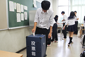 投票箱に票を入れる生徒