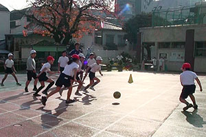 試合でボールを追いかける児童