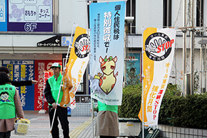 のぼり旗を立てて、駅前ひろばでキャンペーン