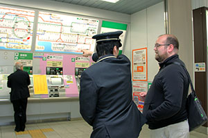 路線図を指さす駅員