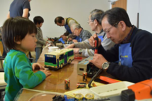 大事なおもちゃの修理を心配そうに見つめる子ども