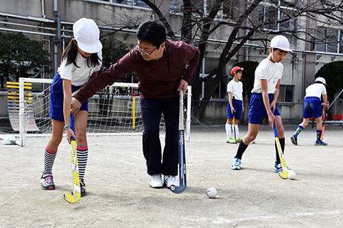 小学生に丁寧に教える大学生の講師