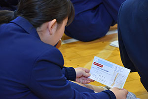 投票所入場整理券を見つめる鈴ヶ森中学生徒