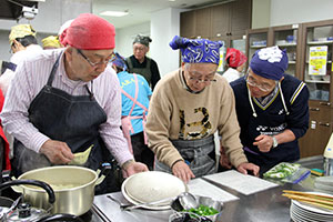 慣れない手つきで料理