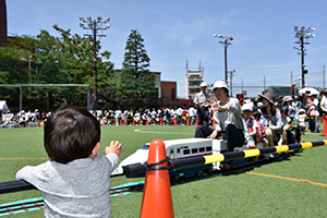 ミニ新幹線に手を振る幼児