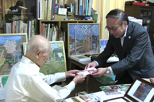 坂田さんにお祝いを手渡す濱野区長