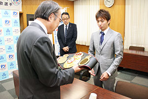 田口選手のチャンピオンベルトを見つめる濱野区長