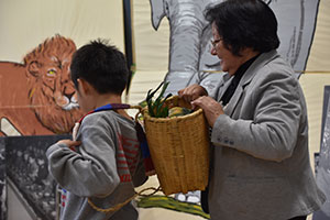 野菜を運ぶかごを背負う児童