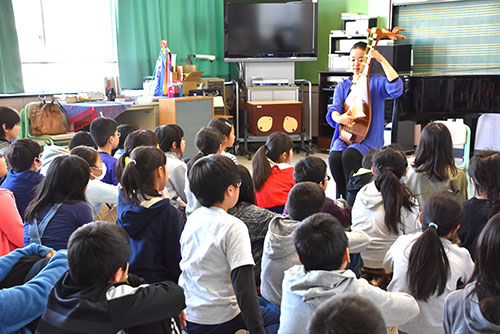 児童の前で琵琶を演奏する榎本さん