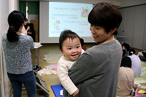 講演会 子どもをあやしながら受講する参加者