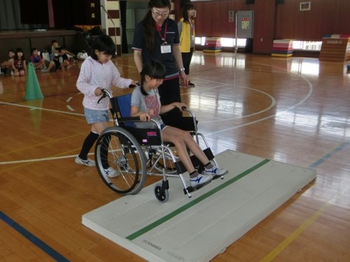 車イスで段差をこえる体験をする女児