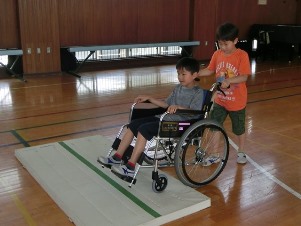 車イスで段差をこえる体験をする男児