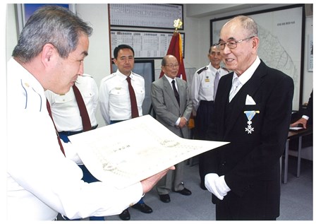 表彰状を手にする飯野会長