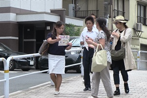 道行く人にＰＲチラシを配る女生徒