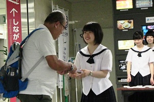 男性にPRちらしを手渡す女子生徒