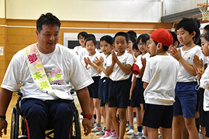 子どもたちの拍手に迎えられる京谷さん