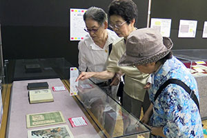 品川にあるお寺の絵をみる来場者