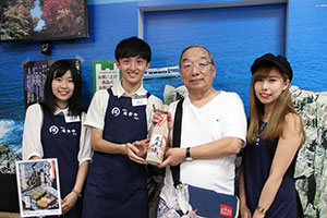 坂井市アンテナショップで購入する田中さん(右から2番目)