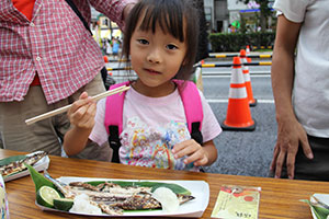 おいしそうにさんまを食べる女の子