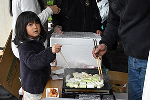 千寿ねぎを焼くお手伝いをする少女