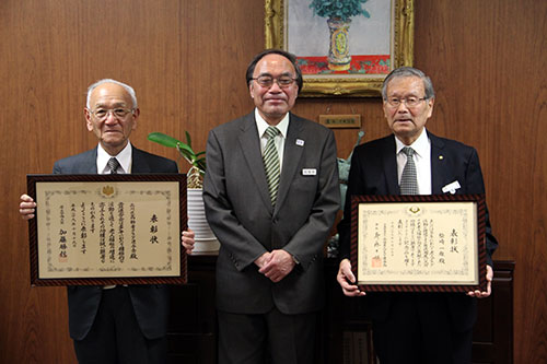 区長との記念写真に収まる品高連会長と前会長