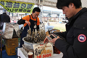 鮎の塩焼きを買う来場者