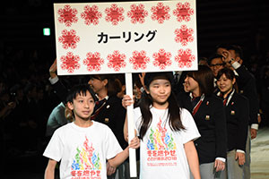 カーリング選手を先導する城南小学校の児童