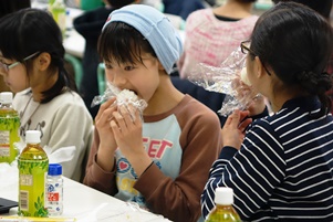 自分で作ったおにぎりをほおばる子どもたち