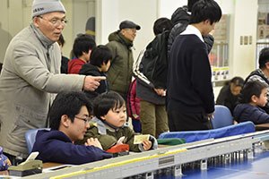 Nゲージを運転する子どもと祖父